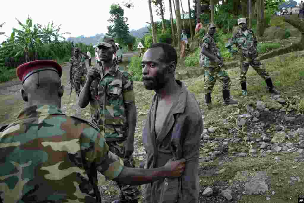 Congolese M23 rebel fighters detain a man they suspect to be an FDLR (Force Democratique de Liberation du Rwanda) rebel returning from an incursion into Rwanda Near Kibumba, north of Goma Nov. 27, 2012.