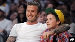 Bintang sepakbola David Beckham (kiri) duduk disamping puteranya, Brooklyn, menyaksikan pertandingan basket NBA di Los Angeles (foto: dok).