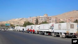 Un convoy de ayuda humanitaria aguarda frente a la agencia de ayuda de la ONU, en las afueras de Damasco, antes de dirigirse hacia Madaya, Siria, el miércoles, 17 de febrero de 2016.
