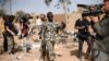 A Malian soldier gestures at journalists to leave the area of a French air strike. Image was taken during an official visit organized by the Malian army to the town of Konna, north of Mali's capital Bamako, January 26, 2013. 