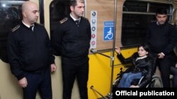 Əlil arabasında metroda hərəkət edən insan