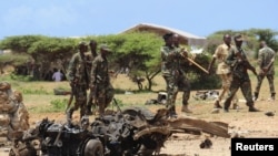 FILE - Jubaland forces walk near the site of an Aug. 22, car bomb attack near a military training base south of Mogadishu.