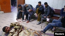 People sit a medical point in the besieged town of Douma, Eastern Ghouta, Damascus, Syria, Feb. 20, 2018.