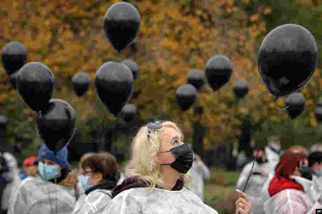 Medical workers hold black balloons in memory of those who lost their lives while in the care of the state health system in Bucharest, Romania.&nbsp;A fire last week at a hospital treating COVID-19 patients in northeastern Romania killed 11 people who were intubated in the intensive care unit.