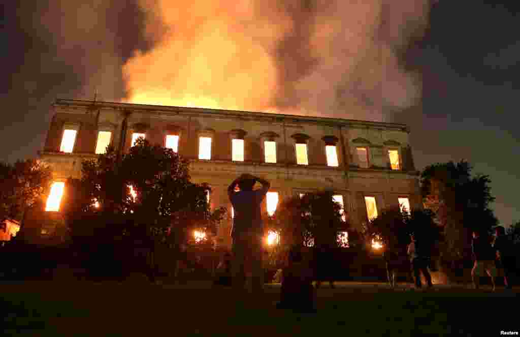 People watch as a fire burns at the National Museum of Brazil in Rio de Janeiro, Brazil, Sept. 2, 2018.