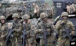 FILE - German Bundeswehr soldiers are seen during exercises with Lithuanian forces at the Rukla military base some 130 kms (80 miles) west of Vilnius, Lithuania, Aug. 25, 2017. Germany was among the driving forces behind the new defense pact.