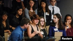 Students from Marjory Stoneman Douglas High School and those supporting them react, Feb. 20, 2018, as they watch the Florida House of Representatives vote down a procedural move to take a bill banning assault weapons out of committee and bring it to the floor for a vote, in Tallahassee, Florida. The lawmakers' move followed last week's mass shooting on the students' campus. 