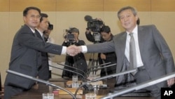 South Korean chief delegate Ryu In-chang, right, shakes hands with his North Korean counterpart Yoon Yong Geun during a meeting to discuss joint research on volcanic activity at the North's highest Paektu mountain, at the Inter-Korean Transit Office in Pa