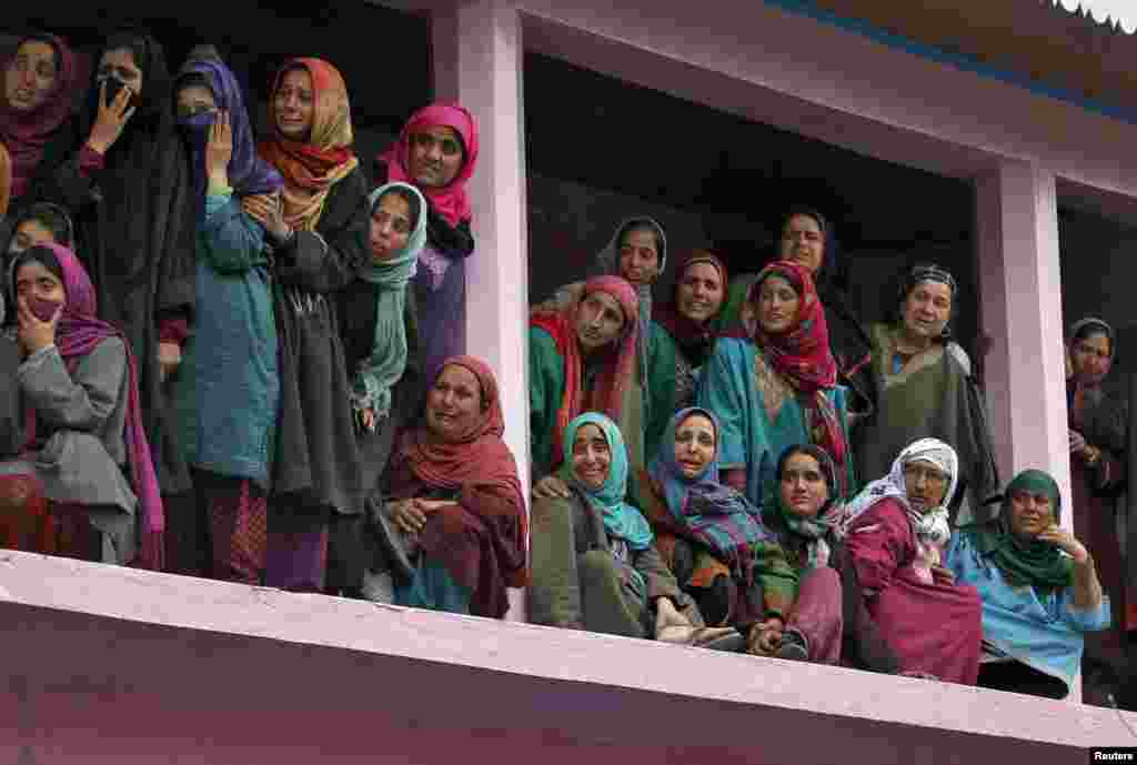 Kashmiri women weep as they watch the funeral procession of Mushtaq Ahmad Wani, an Indian policeman, in Arigam, south of Srinagar. Three unarmed policemen including Wani were killed in south Kashmir after suspected separatist militants opened fire on them during their visit to a neighboring village for investigating a land dispute, police said.