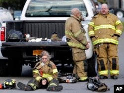 Firefighters take a break while working at the scene of a factory fire in New Windsor, N.Y., Nov. 20, 2017.