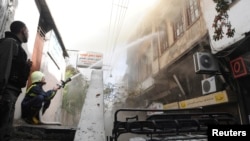 Petugas berusaha memadamkan api setelah serangan mortir menghantam sebuah gedung di Damaskus, Suriah (foto: ilustrasi). 