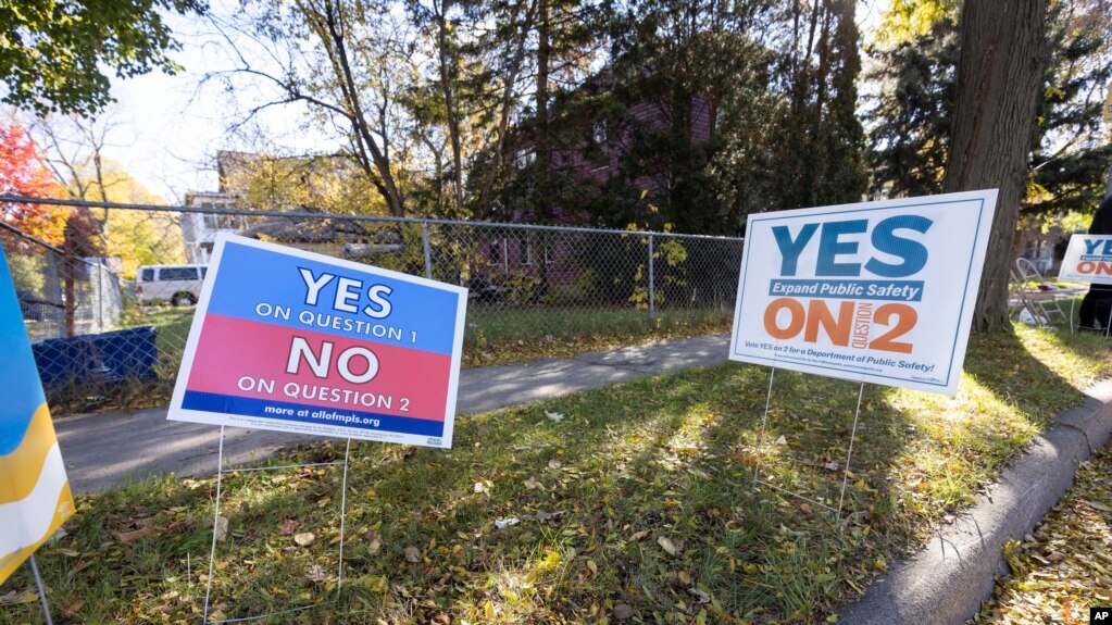 在明尼阿波利斯的一个投票站外，草坪上的一幅标语牌要求选民就取代警察局的公投议题“选票第2问题”投支持票，另一幅呼吁投反对票。(2021年11月2日)(photo:VOA)