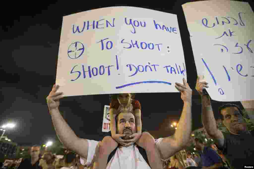 A man holds a sign during a rally in Tel Aviv&#39;s Rabin Square, Aug. 14, 2014.