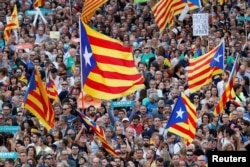 People wave Catalan separatist flags during a demonstration organised by Catalan pro-independence movements ANC (Catalan National Assembly) and Omnium Cutural, following the imprisonment of their two leaders Jordi Sanchez and Jordi Cuixart, in Barcelona.