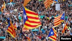 People wave Catalan separatist flags during a demonstration organised by Catalan pro-independence movements ANC and Omnium Cutural, following the imprisonment of their two leaders Jordi Sanchez and Jordi Cuixart, in Barcelona, Oct. 21, 2017.