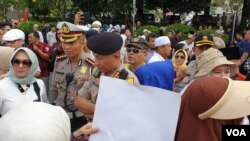 Perwakilan peserta aksi saat negosiasi dengan Polri agar mobil komando diizinkan masuk ke depan gedung Indosat di Jakarta, Jumat (14/6). (VOA/Sasmito)