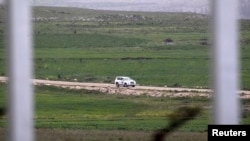 A United Nations vehicle drives near the Syrian village of Al Jamla, close to the ceasefire line between Israel and Syria, as seen from the Israeli occupied Golan Heights March 5, 2013