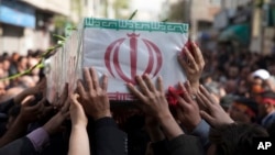 In this picture taken on March 29, 2015, and released by the semi-official Iranian Fars News Agency, a group of mourners carry the flag-draped coffin of Ali Yazdani, a member of Iran's Revolutionary Guard, whom the Guard says was killed during a U.S. drone strike near the Iraqi city of Tikrit. 