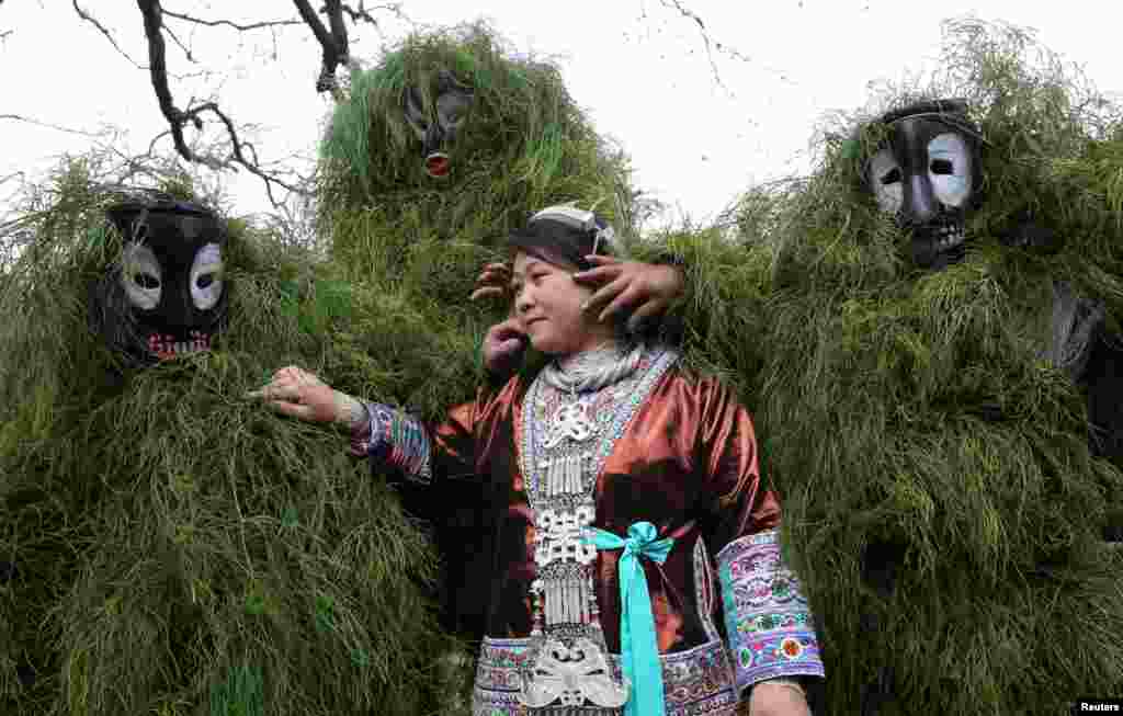 Ethnic Miao men wearing traditional masks smear dust on a woman&#39;s face to wish her good luck during a local celebration event for Lunar New Year in Liuzhou, Guangxi Zhuang Autonomous Region, China, Feb. 5, 2017.