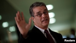 FILE - Roberto Azevedo, director-general of the World Trade Organization, gestures during a news conference in Brasilia, Brazil, March 12, 2018. 