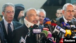 Saad al-Katatni, head of the Egyptian Muslim Brotherhood's Freedom and Justice party, talks during a news conference next to former Foreign Minister Amr Moussa (L) and liberal politician Mohamed ElBaradei (R) after their meeting in Cairo, January 31, 2013.