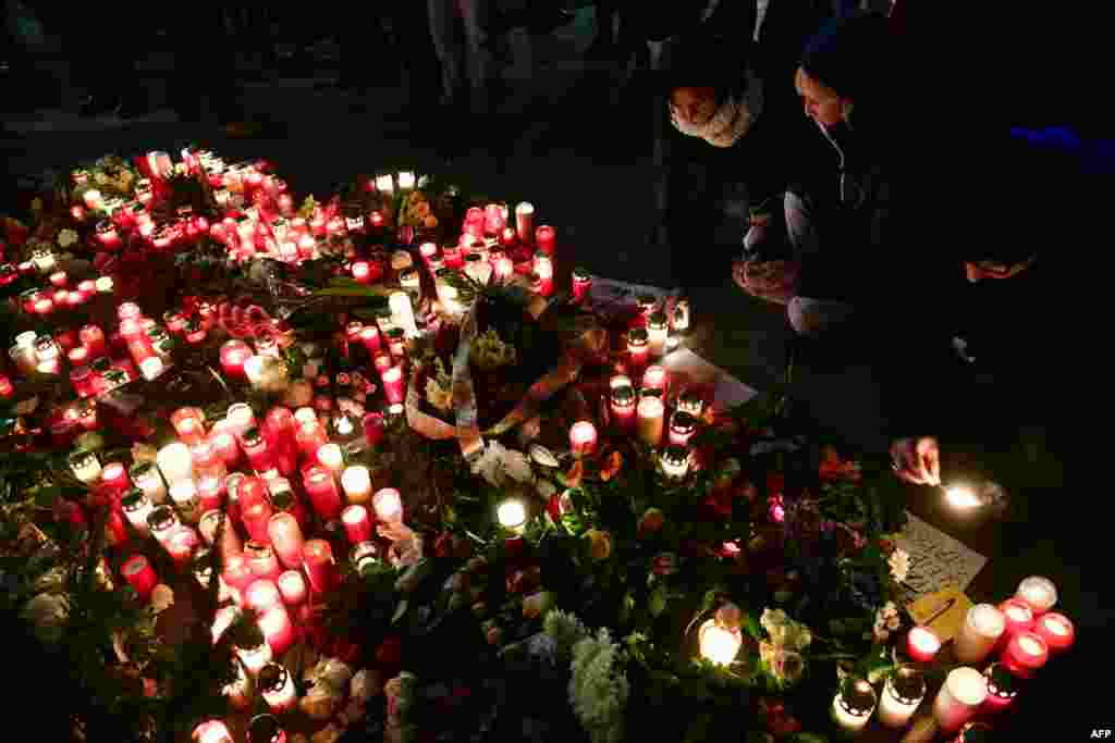 People light candles at a makeshift memorial in front of the Kaiser-Wilhelm-Gedaechtniskirche (Kaiser Wilhelm Memorial Church) in Berlin, where a truck crashed into a Christmas market.