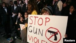 A child holds a sign during a vigil in Los Angeles, California to end gun violence. This vigil was held five days after a gunman killed 20 children and six adults in a shooting at Sandy Hook Elementary School in Newtown, Connecticut on December 14, 2012. (REUTERS/Jason Redmond)