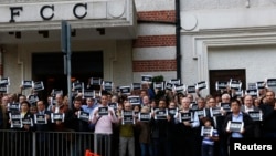 Supporters of French magazine Charlie Hebdo, carrying placards reading "I am Charlie", stage a silent protest outside the Foreign Correspondent Club in Hong Kong, Jan. 8, 2015. 