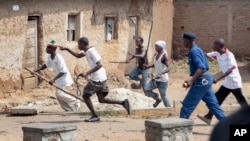 Members of the Imbonerakure pro-government youth militia chase after opposition protesters, unhindered by police, in the Kinama district of the capital Bujumbura, Burundi, May 25, 2015. The militia has recently circulated videos characterized by human rights activists as encouraging genocide against Tutsis.