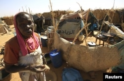 ແມ່ຍິງຄົນໜຶ່ງ ຢືນຢູ່ຄຽງຂ້າງ ບ່ອນພັກຂອງລາວ ກຳລັງແນມເບິ່ງ ຫຼັງຈາກເດີນທາງໄປຮອດສູນ Zam Zam IDP ໃກ້ກັບ ເມືອງ Al Fashir ຢູ່ທາງພາກເໜືອຂອງເຂດ Darfur ປະເທດຊູດານ, ວັນທີ 9 ເມສາ 2015.