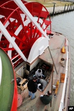 In this Nov. 29, 2018, photo, employees work next to the paddlewheel during the restoration of the City of New Orleans riverboat in New Orleans.