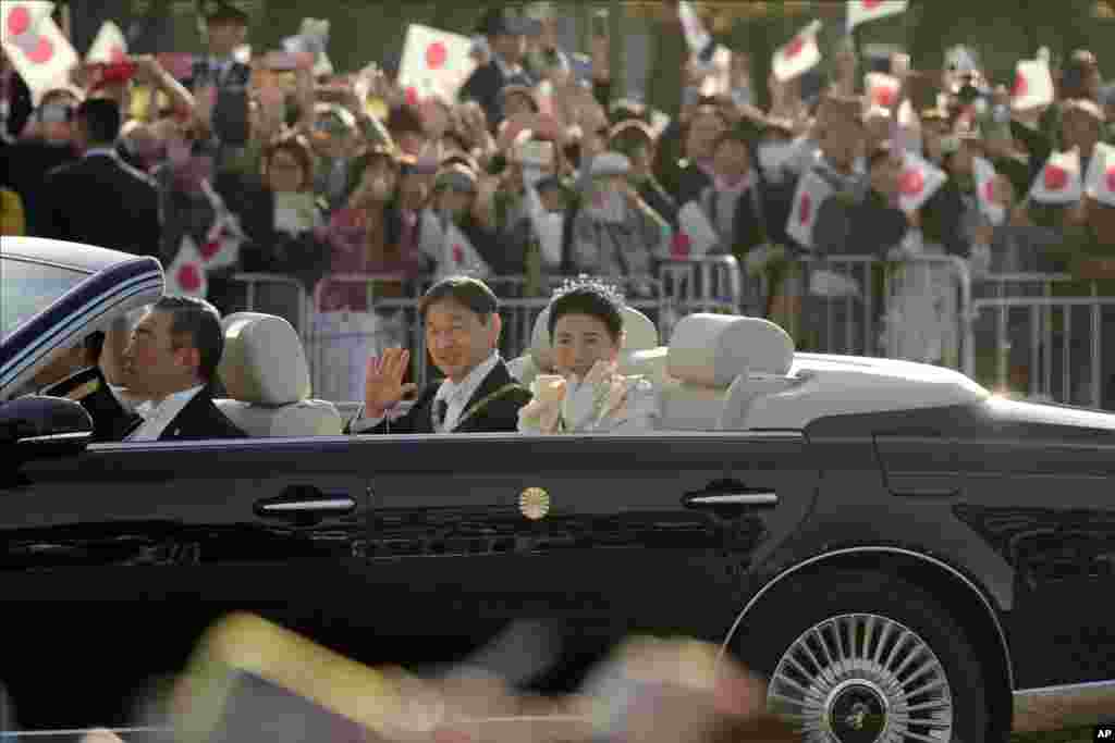 امپراتور ژاپن و همسرش در میان استقبال مردم در توکیو عبور می&zwnj;کنند.