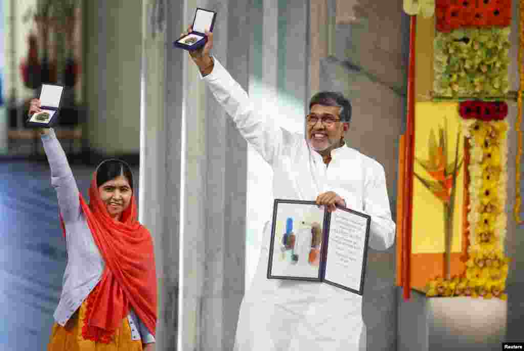 Malala Yousafzai (kiri) dan Kailash Satyarthi berpose dengan medali mereka dalam upacara penyerahan Hadiah Novel di Balai Kota Oslo, Norwegia (10/12).&nbsp;(Reuters/Cornelius Poppe)