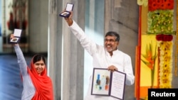 Washindi wa nishani ya nOBEL Malala Yousafzai and Kailash Satyarthi wakiinua medali zao kwa furaha wakati wa hafka ya kupokea huko Oslo,Norway Dec. 10, 2014.