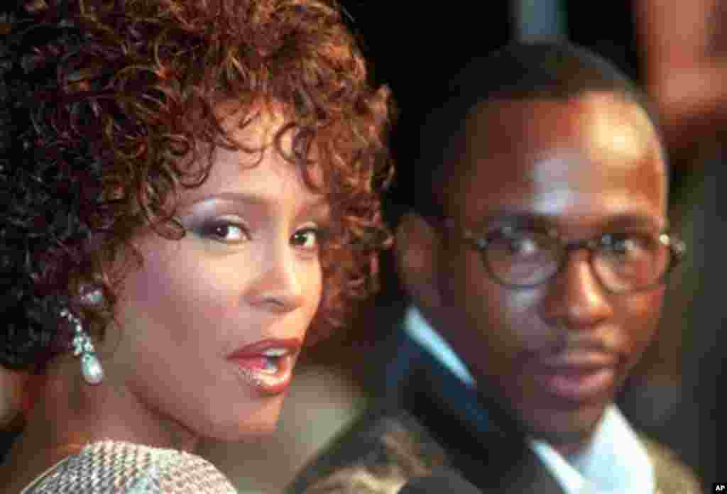 FILE - In this Oct. 13, 1997 file photo, Whitney Houston looks over her shoulder as her husband Bobby Brown looks to her at the premiere of "The Wonderful World of Disney" movie "Cinderella," at Mann's Chinese Theater in the Hollywood section of Los Angel