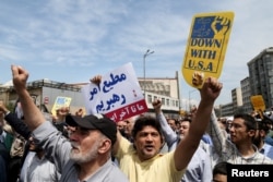 FILE - Iranians shout slogans during a protest against President Donald Trump's decision to walk out of a 2015 nuclear deal, in Tehran, Iran, May 11, 2018.