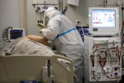 FILE - A medical staff member wearing protective gear attends to a COVID-19 patient at an ICU at the Regional Clinical Hospital 1, in Krasnodar, southern Russia, Nov. 2, 2021.