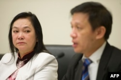 Tran Thi Ngoc Minh, the mother of jailed Vietnamese labor activist Do Thi Minh Hanh, listens as Nguyen Dinh Thang of Boat People SOS (R) speaks about torture and abuse of political and religious prisoners in Vietnam during a press conference on Capitol Hill, Jan. 16, 2014.