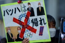 因新冠疫情反对举办东京奥运会的民众在日本首相菅义伟的办公地点外举牌要求取消奥运。（2021年7月29日）