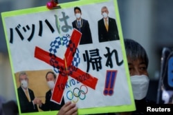 因新冠疫情反對舉辦東京奧運會的民眾在日本首相菅義偉的辦公地點外舉牌要求取消奧運。（2021年7月29日）