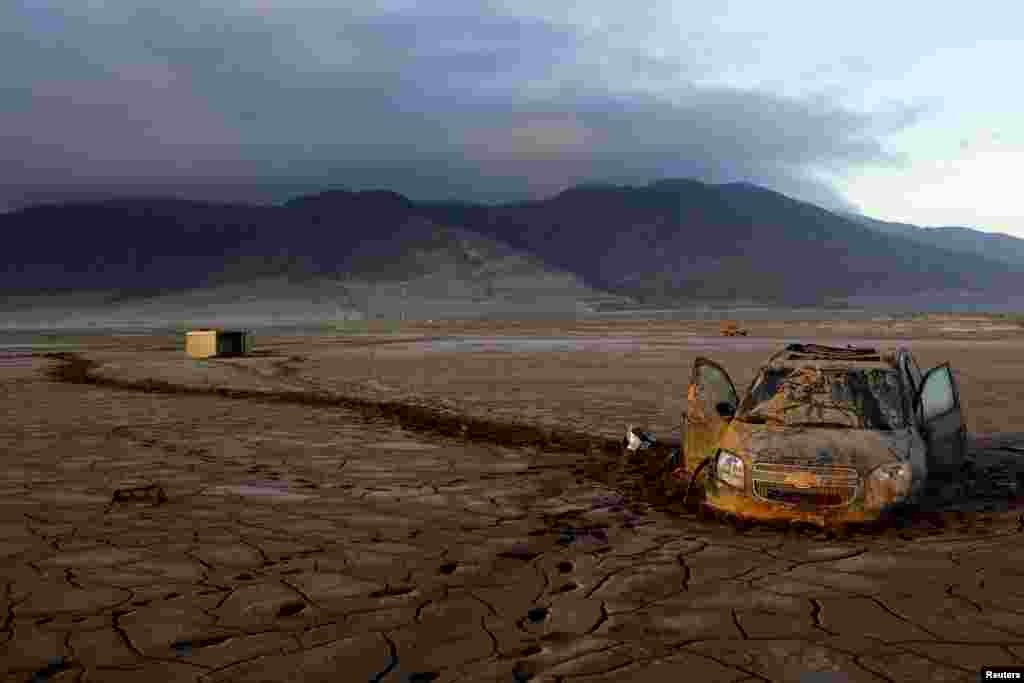 A vehicle partially submerged in dry mud is seen in an area that was hit by floods at Chanaral town, Chile, April 8, 2015. 