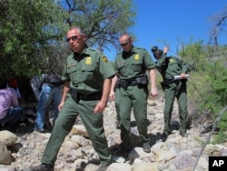 FILE - U.S. Border Patrol Tucson Sector Chief Manuel Padilla, left front, walks with other agents and media during a tour in the Buenos Aires National Wildlife Refuge near Sasabe, Arizona.