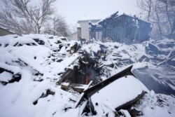 A flame flickers in the remains of a home destroyed by a pair of wildfires, Jan. 1, 2022, in Superior, Colorado.