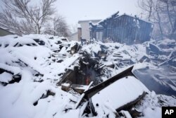 A flame flickers in the remains of a home destroyed by a pair of wildfires, Jan. 1, 2022, in Superior, Colorado.