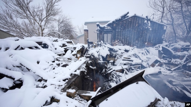 Una llama parpadea en los restos de una casa destruida por un par de incendios forestales, el 1 de enero de 2022, en Superior, Colorado, EE. UU.