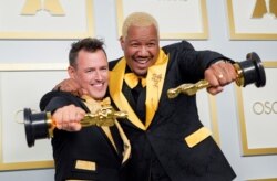 Martin Desmond Roe dan Travon Pose berpose dengan piala mereka untuk Film Pendek Terbaik "Two Distant Strangers" di ruang pers acara penganugerahan piala Oscar, di Los Angeles, California, AS, 25 April 2021. (Chris Pizzello / Pool via REUTERS)