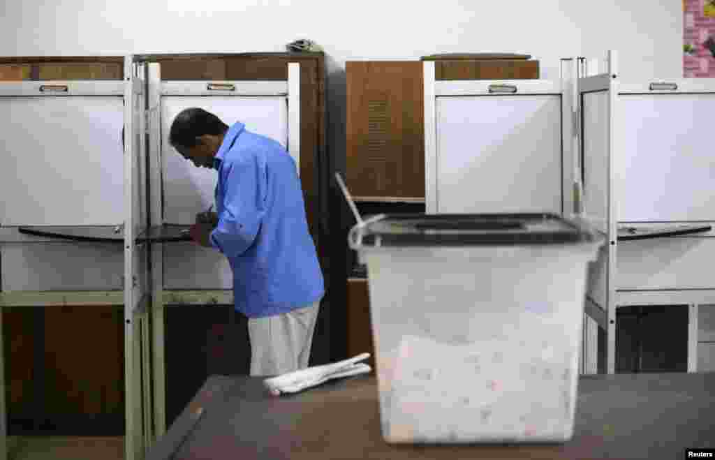 A voter casts his ballot in a polling station near the Saladin Citadel on the third day of voting in the Egyptian presidential election in Cairo, May 28, 2014.