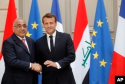 FILE - French President Emmanuel Macron skakes hands with Iraqi Prime Minister Adel Abdul-Mahdi after a joint statement at the Elysee Palace in Paris, France, May 3, 2019.