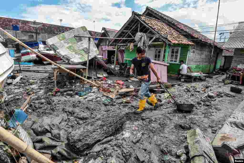 Seorang pria membersihkan lingkungan sekitar rumahnya setelah tsunami melanda Anyer, provinsi Banten. (Foto: Antara)