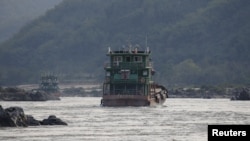 FILE - Chinese cargo ships sail on the Mekong river near the Golden Triangle at the border between Laos, Myanmar and Thailand March 1, 2016.